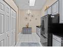 Bright kitchen with stainless steel appliances, modern cabinets, tile flooring and large pantry/closet at 39650 Us Highway 19 N # 244, Tarpon Springs, FL 34689