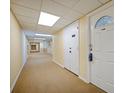 Long hallway features neutral carpet, lighting, doors and utility closet in a condominium building at 400 64Th Ave # 1108, St Pete Beach, FL 33706