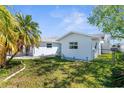 This backyard features a lush lawn, privacy fence, and the home's exterior with ample natural light at 4390 6Th Isle Dr, Hernando Beach, FL 34607