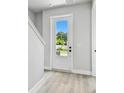 Bright foyer with a white front door with glass and light wood flooring at 4717 W Mccoy St # 9, Tampa, FL 33616