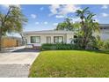 Charming single-story home featuring a well-manicured lawn, lush shrubbery, and a welcoming front porch at 4834 W Flamingo Rd, Tampa, FL 33611