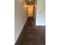 Hallway with carpet and white walls, leading to a door, showing interior access and layout at 4983 Puritan Cir # 524, Tampa, FL 33617