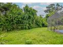 Spacious backyard surrounded by lush greenery, offering privacy and a connection with nature at 5101 Estates Cir, Sarasota, FL 34243