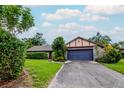 Inviting single-story home with a well-maintained lawn, large driveway, and attached two-car garage at 5101 Estates Cir, Sarasota, FL 34243