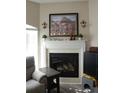 Comfortable seating near a fireplace with decorative mantle, plants and decorative wall sconces at 6513 Sand Shore Ln, New Port Richey, FL 34652