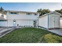 Charming two-story home with light blue accents, green lawn and storage shed at 7 Georgia Ave, Crystal Beach, FL 34681