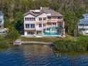 Waterfront home with a pool, balconies, and outdoor living spaces, perfect for enjoying the coastal lifestyle at 812 Point Seaside Dr, Crystal Beach, FL 34681