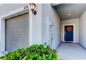 Close-up showcasing the entrance of a home, featuring a garage, front door, and decorative plants at 8294 Corner Pine Way, New Port Richey, FL 34655