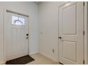 Bright entryway featuring neutral tile flooring, white walls, a decorative glass door and a coat closet at 8294 Corner Pine Way, New Port Richey, FL 34655