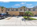 Inviting townhome exterior featuring a well-manicured lawn, a garage, and beautiful landscaping at 8421 Pine River Rd, Tampa, FL 33637