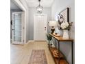 Welcoming foyer featuring a console table, stylish lighting, and wood-look tile flooring at 8887 Little Bluestem Dr, Land O Lakes, FL 34637