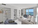 Bright living room with built in shelves, comfortable seating, and balcony access with stunning ocean view at 9 Haig Pl # 310, Dunedin, FL 34698
