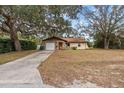 Single-story home featuring stone accents and an attached garage with a spacious front yard at 9287 Horizon Dr, Spring Hill, FL 34608