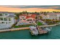Waterfront property with a private dock, boat, lush lawn, pool, and outdoor kitchen at 940 Monte Cristo Blvd, Tierra Verde, FL 33715