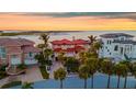 Elegant waterfront home boasting a red tile roof, multiple balconies, and manicured palm trees at 940 Monte Cristo Blvd, Tierra Verde, FL 33715