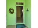 Inviting home entrance featuring a decorative wreath and bright, fresh decor at 1318 Misty Greens Dr, Sun City Center, FL 33573