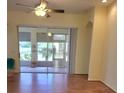 Bright living room featuring hardwood floors and a large glass door leading to the lanai at 1318 Misty Greens Dr, Sun City Center, FL 33573