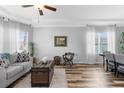 Cozy living room with wood floors, tray ceiling, neutral walls, and abundant natural light through sheer curtains at 13424 Hunters Point St, Spring Hill, FL 34609