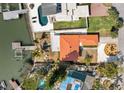 Expansive aerial view of the home featuring a vibrant orange roof, private pool, and a lush landscape at 14184 W Parsley Dr, Madeira Beach, FL 33708