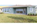 The backyard has sliding glass doors, a concrete patio, and a well-maintained lawn for outdoor enjoyment at 31430 Hayman Loop, Wesley Chapel, FL 33545