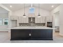 Modern kitchen with a large island, pendant lighting, and ample cabinet space at 31430 Hayman Loop, Wesley Chapel, FL 33545