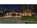 Stunning home exterior at night, featuring a long drive and three-car garage at 3668 Janus Way, Palm Harbor, FL 34685