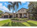 Beautiful home with a well-manicured lawn and garden beds, with a circular driveway at 3668 Janus Way, Palm Harbor, FL 34685