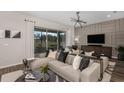 Comfortable living room featuring a large sectional sofa, textured wall, and sliding glass doors to the outside at 37195 Clinch Cir, Zephyrhills, FL 33540