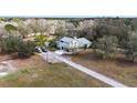 An aerial view of a secluded country home with a long driveway and surrounded by dense, natural woodland at 403 Indian Meadow Ct, Wimauma, FL 33598