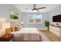 Cozy bedroom features neutral tones, a ceiling fan, and a bright window for lots of natural light at 5200 Dove Dr, New Port Richey, FL 34652