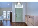 Welcoming foyer featuring a green door, wood floors, high ceilings, and elegant decor at 6427 Weatherwood Cir, Wesley Chapel, FL 33545