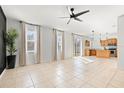 Expansive living area merges seamlessly with a kitchen featuring modern pendant lights, tile flooring, and stainless appliances at 707 Fern Leaf Dr, Ruskin, FL 33570