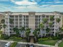 Exterior of condo building featuring multiple floors, balconies, manicured landscaping, and ample parking at 7194 Key Haven Rd # 405, Seminole, FL 33777