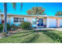 Charming single-story home with a well-maintained lawn and a cozy front porch seating area at 858 Cambridge Ct # 858, Dunedin, FL 34698