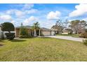 Well-manicured lawn and charming front exterior of single-story home with attached garage and beautiful trees at 9550 134Th St, Seminole, FL 33776