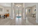 Bright foyer with wood-look tile flooring, double entry doors, and views into adjacent living spaces at 10218 Garden Alcove Dr, Tampa, FL 33647