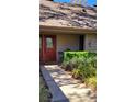 Inviting front entrance featuring a red door and lush green shrubbery at 1102 Old Mill Pond Rd, Palm Harbor, FL 34683