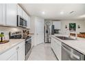 Bright kitchen with white cabinets, stainless steel appliances, granite counters, and a center island at 11508 Timber Grove Ln, Brooksville, FL 34613