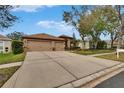 Charming single-story home featuring a well-maintained lawn, beautiful landscaping, and a two-car garage at 1220 Emerald Hill Way, Valrico, FL 33594