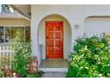 Close-up of the arched front door featuring an ornate wood design and inviting curb appeal at 1831 Kay Dr, Largo, FL 33770