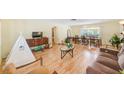 Open-concept living room with wood floors, neutral walls, and ample natural light from the windows at 1831 Kay Dr, Largo, FL 33770