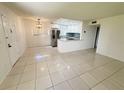 Bright living room with tile flooring and an open view into the modern kitchen with stainless steel appliances at 3300 Fox Chase N Cir # 229, Palm Harbor, FL 34683