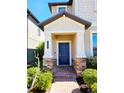 Inviting home entrance featuring a classic blue door, brick walkway, and stone accents at 3367 Janna Grace Way, Land O Lakes, FL 34638