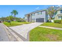 View of the home showing the interlocking brick driveway, gray paint and black shutters at 3709 W Dale Ave, Tampa, FL 33609