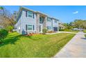 Two-story home featuring stone accents, gray paint, dark shutters and manicured front yard at 3709 W Dale Ave, Tampa, FL 33609