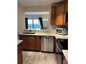 Stainless steel dishwasher and sink in the kitchen with light countertops at 4237 Brentwood Park Cir, Tampa, FL 33624