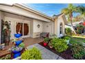 Covered entryway with seating area and manicured landscaping, creating an inviting curb appeal at 4614 Sandpointe Dr, New Port Richey, FL 34655