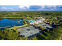 Aerial view of community amenities including tennis courts, pool, lake, and community center amidst lush landscaping at 5513 Creek Ridge Rd, Brooksville, FL 34601