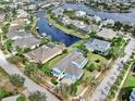 Aerial view of a waterfront neighborhood showcasing a blue home with lush landscaping and canal access at 613 Manns Harbor Dr, Apollo Beach, FL 33572
