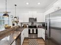 Modern kitchen with stainless steel appliances, white cabinetry, granite countertops, and an undermount sink at 6930 Ripple Pond Loop, Zephyrhills, FL 33541